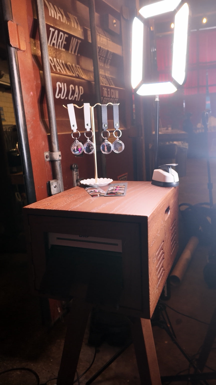 Oakwood Photo Booth printer and keychain display with event lighting