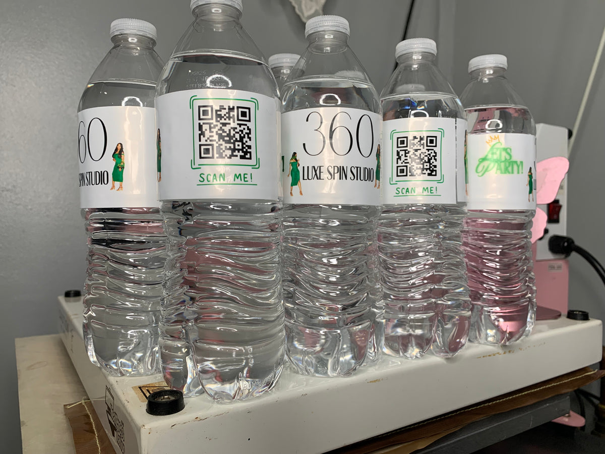 Water bottles with Luxe Spin Studio branding and QR-code labels.