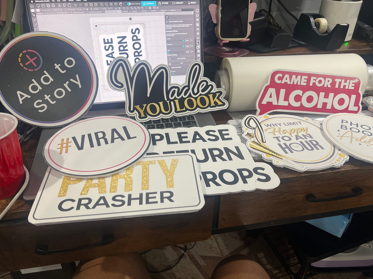 Assorted handheld photo booth props with colorful party sayings.
