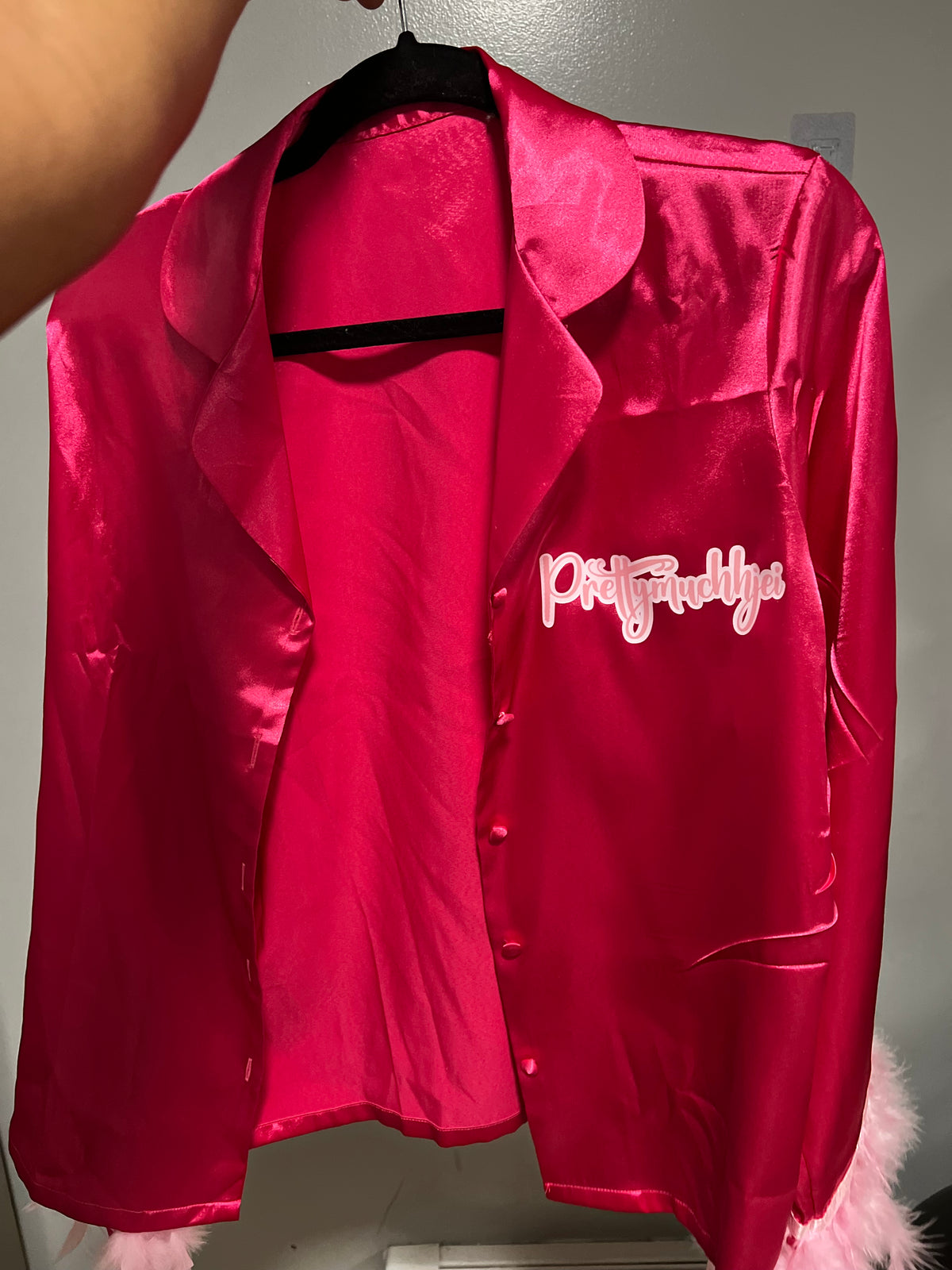 Pink pajama top with white personalized lettering across the chest.